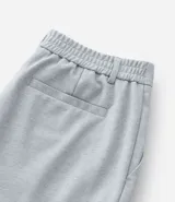 Pantalón de vestir gris con textura, corte slim, con trabillas en la cintura y cierre por botón y cremallera.