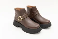 Borcego de cuero negro con plataforma y hebilla dorada decorativa.