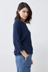 Blusa color crudo con escote en V y mangas largas.