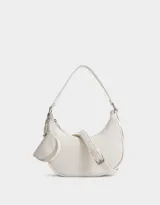 Bandolera color blanco crudo de cuerina, con asa de hombro y pouch lateral con cierre y charm de metal.