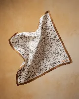 Pañuelo de seda 100% natural, color blanco con estampado de puntos irregulares en tonos marrones, negros y beige, y borde marrón liso. Incluye la firma de la artista en color naranja.