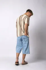 Remera de tejido de punto color crudo con rayas verticales marrones y negras, de manga corta y corte recto.