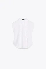 Camisa blanca de popelín con cuello solapa y sisa. Presenta pinzas delanteras y cierre frontal con botones ocultos por solapa.