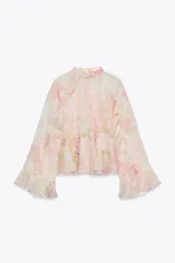 Camisa de cuello subido y manga larga con estampado floral en tonos rosa y verde. Detalle de volantes en cuello, mangas y ruedo. Cierre en espalda con abertura y botones.