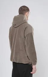 Hoodie anorak verde militar de tela polar con calce relajado, elástico en puños y cintura, bolsillo central con cierre y dos bolsillos laterales ocultos.