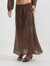 Falda larga marrón de tejido arrugado liviano, con cintura elástica y terminación Polonio en cobre.