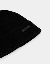 Gorro de lana negro con etiqueta de cuero sintético con logo de la marca.