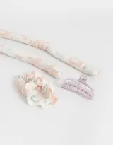 Set de accesorios para el pelo que incluye un rulero sin calor, dos scrunchies y un broche.