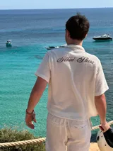 Camisa de waffle color crema con cuello polo, mangas cortas y bordado marrón en la espalda.