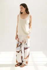 Musculosa blanca con estampado abstracto en tonos marrones y celestes, con cuello redondo y sisas con ribete en color crudo.