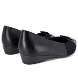 Zapato de vestir Usaflex Viena, color negro, con capellada de cuero y laterales de tejido elástico. Presenta detalle de hebilla plateada en la punta y taco bajo.