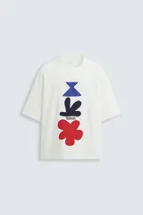 Camiseta blanca de corte regular, cuello redondo y manga corta. Presenta parches geométricos en azul, negro y rojo en el frente y estampado en la espalda.