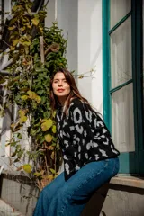 Buzo de punto color negro con estampado animal print en gris claro, de corte holgado y manga larga.