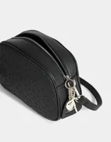 Bandolera negra de cuerina con corazones en relieve, correa regulable desmontable, acceso mediante cierre superior y puller de material principal con charms de corazones y perlas.