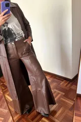Pantalón de cuero marrón de corte palazzo con paneles y costuras a la vista.
