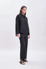 Pantalón negro con bordado calado, de corte palazzo y tiro alto.
