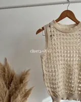 Chaleco tejido de algodón color crema con diseño calado.
