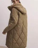 Campera puffer color beige con cuello alto, cierre frontal con cremallera y bolsillos laterales.