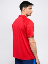 Remera polo de entrenamiento color azul marino, con cuello tipo henley de tres botones y mangas cortas. Presenta un patrón texturizado en los hombros y el escudo del Club Nacional de Football en el pecho izquierdo.