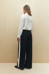 Pantalón de jogging color crema con cintura elástica, cordón ajustable y franja lateral negra.