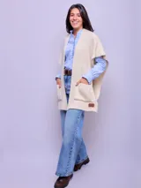 Ruana color crudo de lana merino natural sin teñir, con bolsillos frontales y corte holgado.