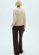 Sweater color beige de tejido de punto con cuello redondo y mangas largas.