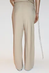 Pantalón de algodón color beige, de corte amplio y tiro alto, con cintura elástica ajustable con cordones y bolsillos laterales.