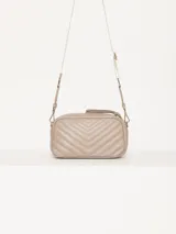 Bandolera color beige con diseño acolchado en forma de V y logo metálico dorado en forma de labios. Tiene correa larga ajustable y herrajes plateados.