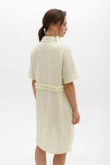 Vestido camisero a rayas con cuello y cartera en tono lima claro, volados frontales y laterales. De calce relajado y mangas cortas. Fabricado en Uruguay.