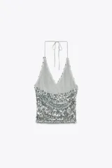 Top plateado con lentejuelas, cuello halter ajustable con lazada y forro interior de tul.