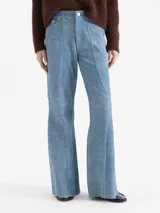 Pantalón ancho de cuero ovino con terminación símil denim, color azul. Presenta recortes curvos en las piernas, cierre y botón tipo jeanero, y bolsillos plaqué en la espalda.