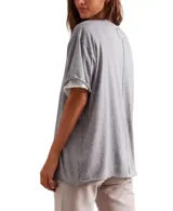 Remera gris de corte cuadrado, ligeramente extragrande, con escote redondo, hombros caídos y costuras sin rematar.