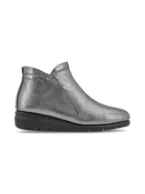 Botín de cuero sintético metalizado color gris, con elástico lateral y suela de goma negra.