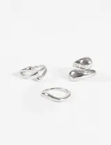 Set de tres anillos plateados con diseño curvo y orgánico, de diferentes grosores.