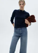 Pantalón de jean azul de tiro alto, corte culotte, con cierre de cremallera y botón, trabillas, bolsillos traseros, bajo deshilachado y tejido elástico.