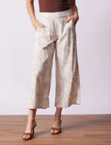 Pantalón crop de lino estampado con hojas en tonos verdes y azules. Tiene pretina trasera elastizada y bolsillos delanteros.