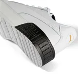 Championes Puma modelo Carina 2.0 para mujer, color blanco con franja lateral (Formstrip) negra. Presentan una plataforma gruesa con textura acanalada en la puntera y el talón, y cordones blancos.