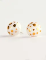 Par de aros tipo botón blancos con puntos dorados.