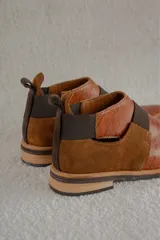 Bota corta color borgoña con textura de reptil, puntera fina, elástico negro en el empeine y talón descubierto.