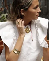 Brazalete rígido plateado con textura irregular.