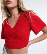 Blusa cropped de punto color verde, con escote cruzado en V y mangas cortas.