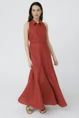 Vestido largo color ladrillo, sin mangas, con cuello camisero, cierre frontal con cremallera y lazo ajustable en la cintura.