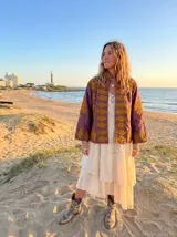 Chaqueta color morado con bordados dorados, cuello mao y corte recto.