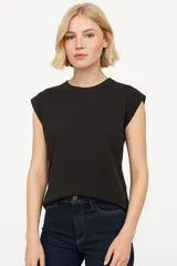Remera blanca de algodón con cuello redondo y mangas cortas con hombreras.