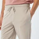 Short deportivo color beige, estilo jogger, con cintura elástica y cordón ajustable.
