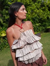 Collar con tira de cuero color suela y dije metálico dorado en forma de estribo.