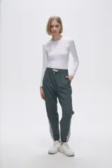 Pantalón de jogging color celeste con cintura elástica ajustable con cordón y puños elásticos. Presenta tres tiras verticales blancas en la parte inferior de la pierna.