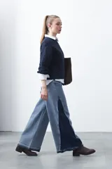 Jean de calce ultra wide confeccionado en denim de algodón color negro. Presenta una silueta amplia desde la cadera y un panel lateral en contraste que estiliza la pierna.