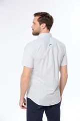 Camisa azul marino lisa de manga corta con cuello abotonado, cierre frontal con botones y bolsillo en el pecho. Confeccionada en algodón.