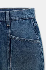 Falda pantalón de denim azul, de tiro medio, con bolsillos delanteros y traseros. Cierre frontal con cremallera y botón metálico.